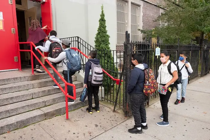 A teacher leads a group of her students into PS 179 elementary school in the Kensington neighborhood of Brooklyn in September.
